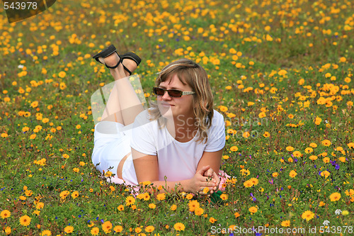 Image of Young girl relaxing on a flowers meadow