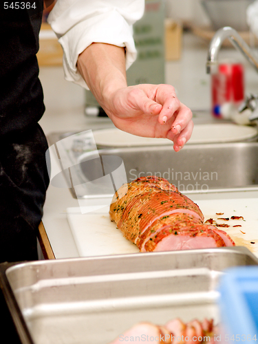 Image of Chef preparing ham in kitchen