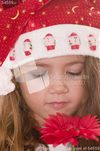 Image of Little Santa smelling a flower