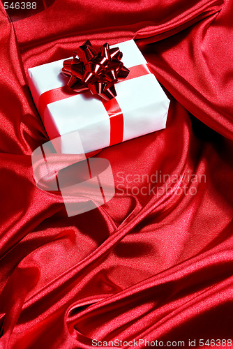 Image of gift box on red satin background