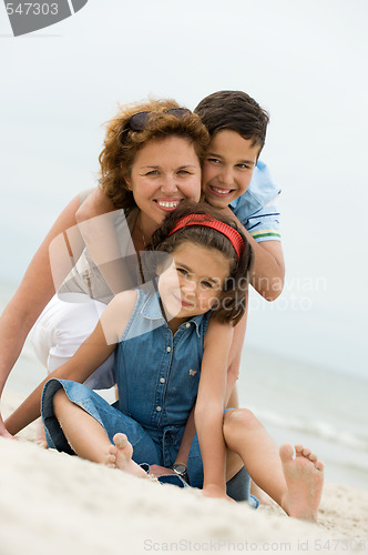 Image of Happy mother and kids on the beach