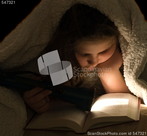 Image of Child Reading In The Dark