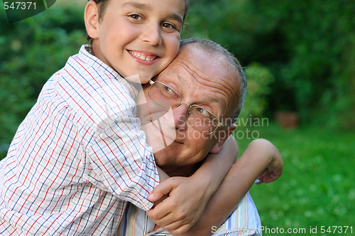 Image of Smiling grandfather and kid outdoors