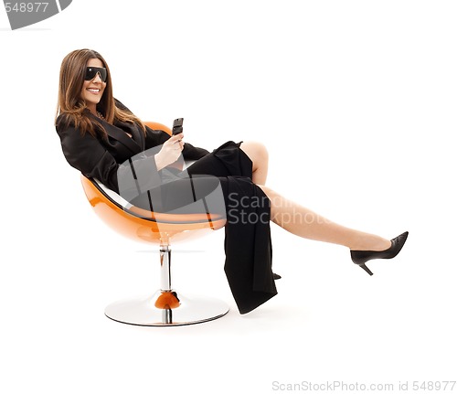 Image of businesswoman with phone in orange chair