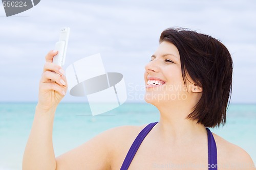 Image of happy woman with phone on the beach