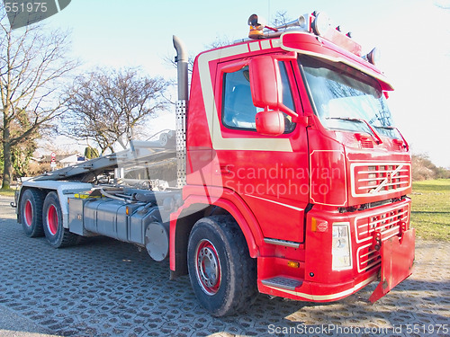 Image of Front side view of red skip truck with hydraulic arm