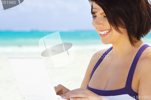 Image of woman with laptop computer on the beach