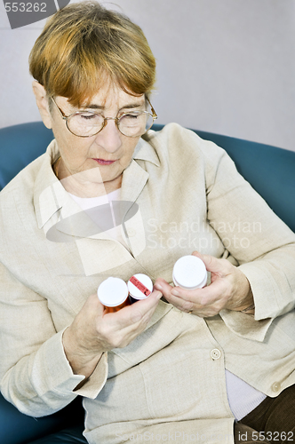 Image of Elderly woman reading pill bottles