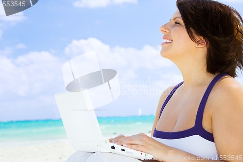 Image of woman with laptop computer on the beach