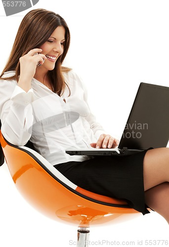 Image of businesswoman in chair with laptop and phone