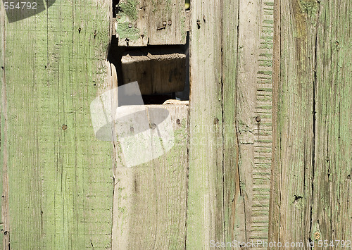 Image of hole in wooden fence