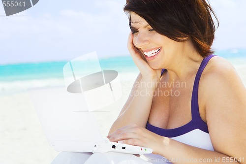 Image of woman with laptop computer on the beach