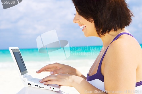 Image of woman with laptop computer on the beach