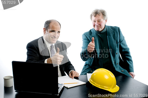 Image of two business partners at desk shaking hands