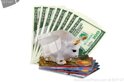 Image of Figure of a white bull with gold horns standing on a pile of credit cards and dollars