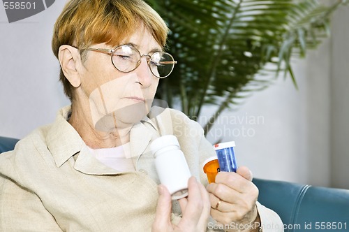 Image of Elderly woman reading pill bottles