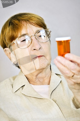 Image of Elderly woman reading pill bottles