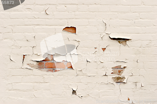 Image of peeling paint over brick wall