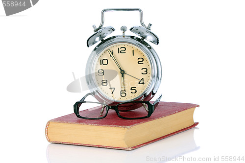 Image of book with alarm clock and eyeglasses 