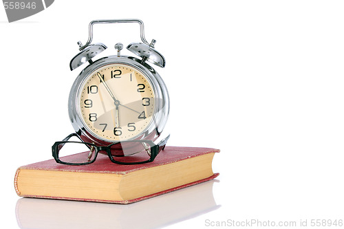 Image of book with alarm clock and eyeglasses 