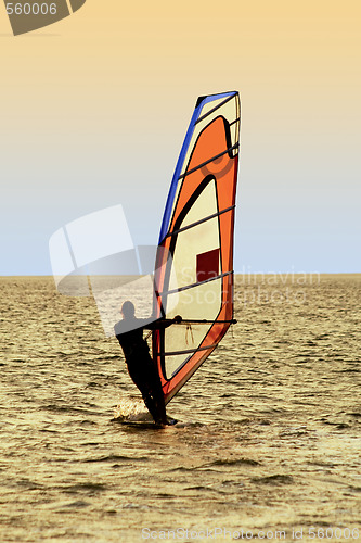 Image of Silhouette of a windsurfer on waves of a sea 