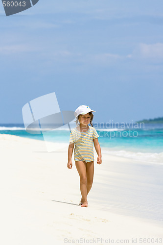 Image of A young girl walking on the beach