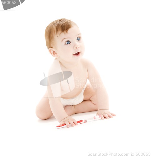 Image of baby boy in diaper with toothbrush