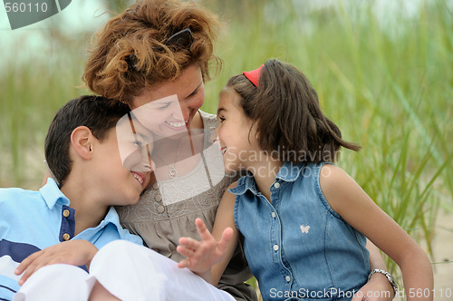 Image of Happy mother and kids on the beach