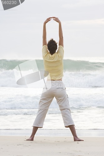 Image of Woman doing yoga on beach