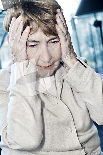 Image of Elderly woman holding head