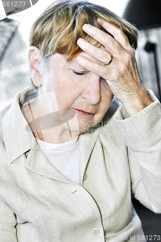 Image of Elderly woman holding head