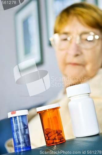 Image of Elderly woman looking at pill bottles