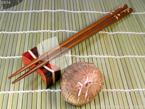 Image of Chopsticks and mushroom over a bamboo background