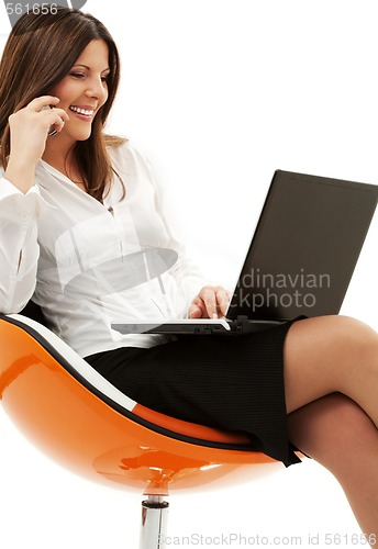 Image of businesswoman in chair with laptop and phone