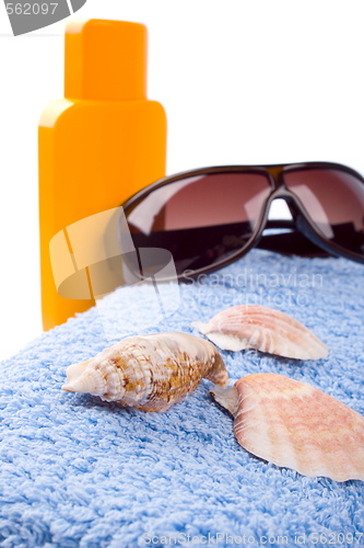 Image of towel, shells, sunglasses and lotion