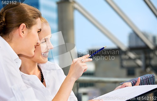 Image of two happy businesswomen with paper chart