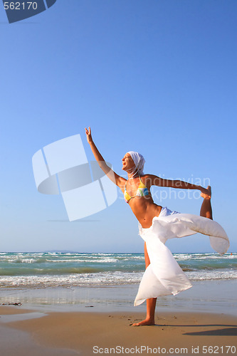 Image of Beautiful girl meditating on the beach