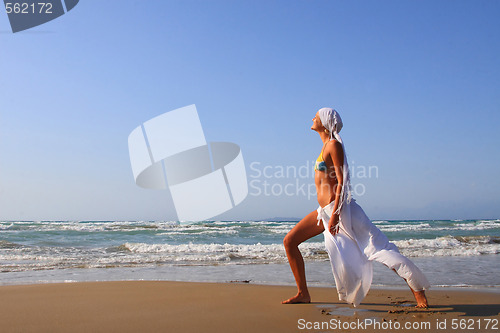 Image of Beautiful girl meditating on the beach