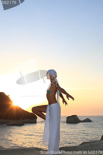 Image of Woman meditating at sunset