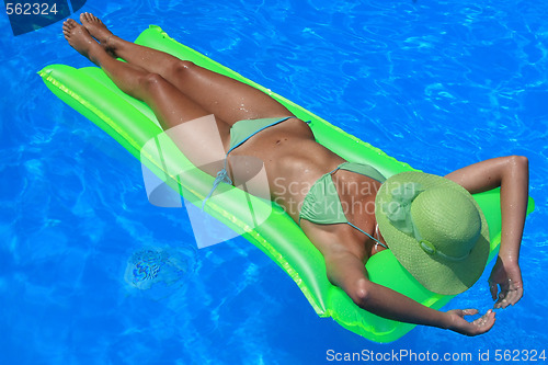 Image of Woman lying on an air matress in blue pool