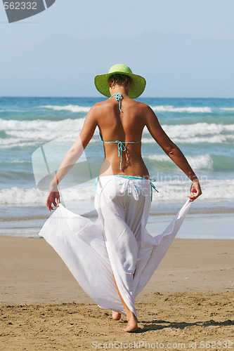 Image of woman standing on shoreline at the beach in Greece