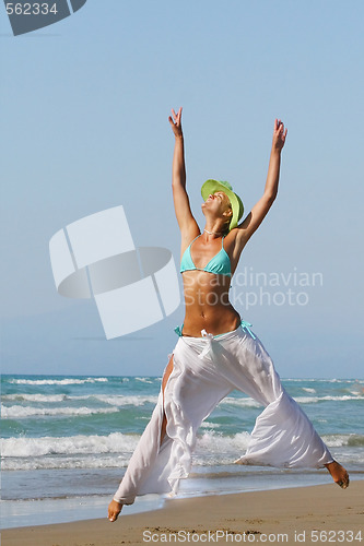 Image of woman standing on shoreline at the beach in Greece