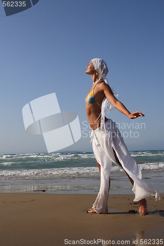 Image of woman standing on shoreline at the beach in Greece