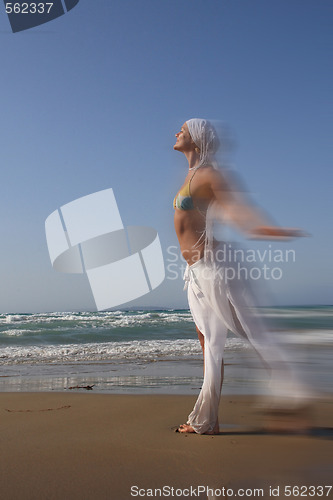 Image of woman standing on shoreline at the beach in Greece