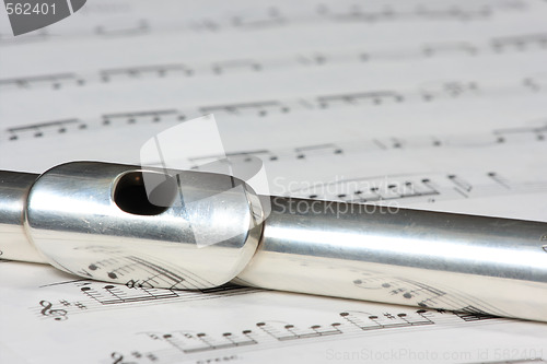 Image of Silver flute instrument resting on a music score