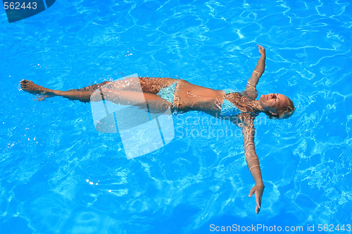 Image of Young woman enjoying a swimming pool