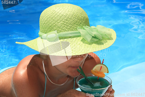 Image of Woman enjoying a fresh cocktail in a blue pool