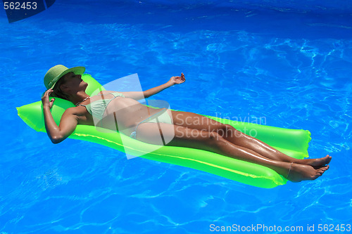 Image of Woman lying on an air matress in blue pool