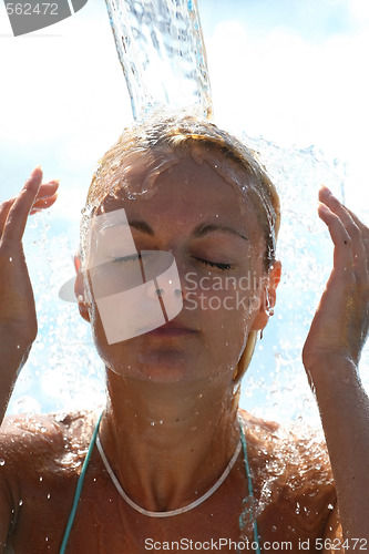 Image of Young beautiful happy smiling tanned blond woman in bikini at rain or summer shower on sea beach