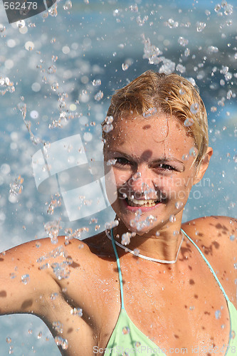 Image of Young beautiful happy smiling tanned blond woman in bikini at rain or summer shower on sea beach